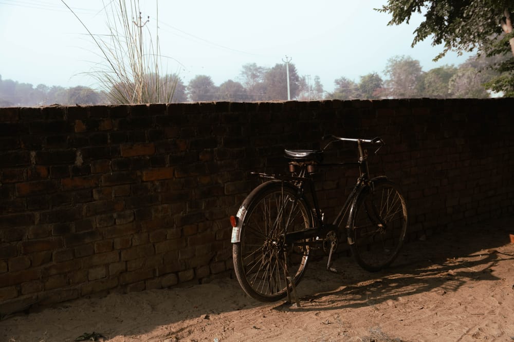 Bicycle leaning on a low brick wall in dusty afternoon light
